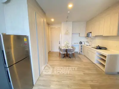 Modern kitchen with dining area and stainless steel fridge in stylish apartment