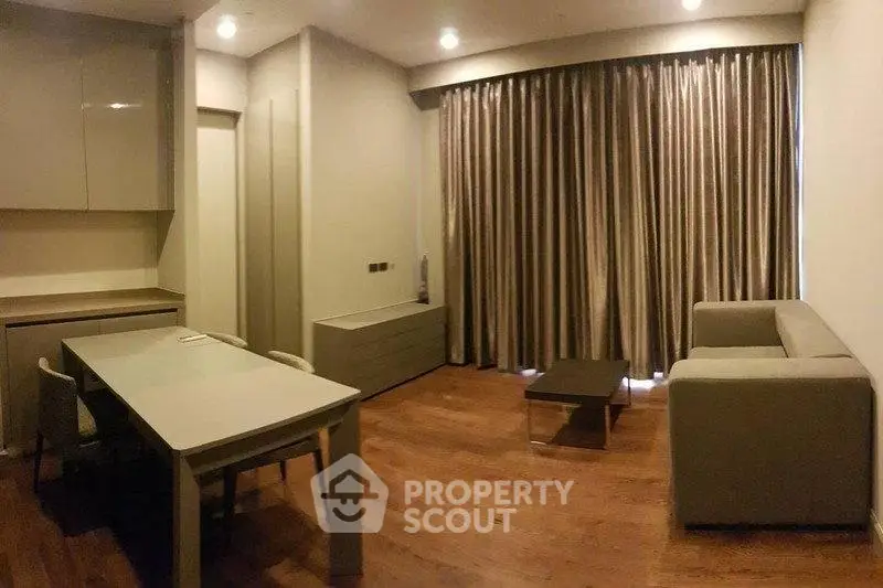 Modern living room with sleek furniture and floor-to-ceiling curtains, perfect for urban living.