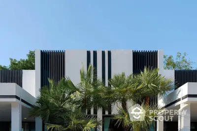 Modern architectural building facade with palm trees and sleek design