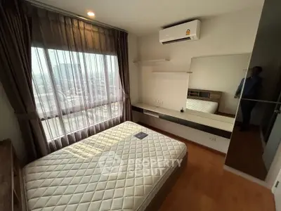 Modern bedroom with large window and air conditioning in a high-rise apartment.