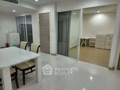 Spacious modern dining area with sliding glass doors leading to a versatile room, ideal for family living.