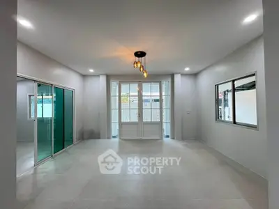 Spacious modern living room with elegant lighting and large windows for natural light.