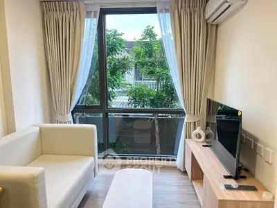 Modern living room with large window, cozy sofa, and sleek TV setup.