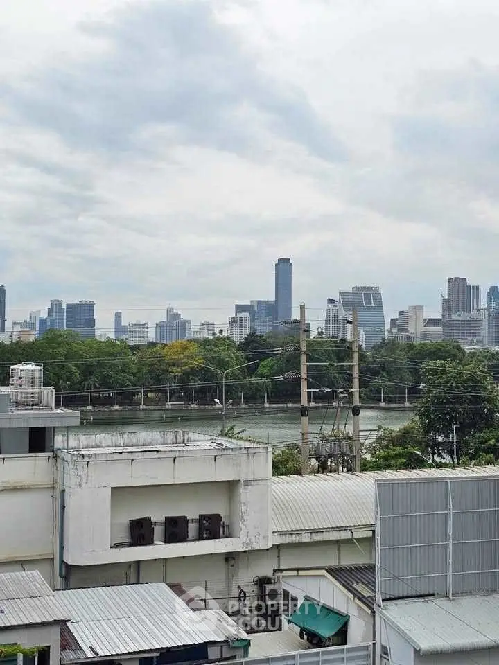 Stunning urban skyline view from a high-rise building, showcasing cityscape and greenery.