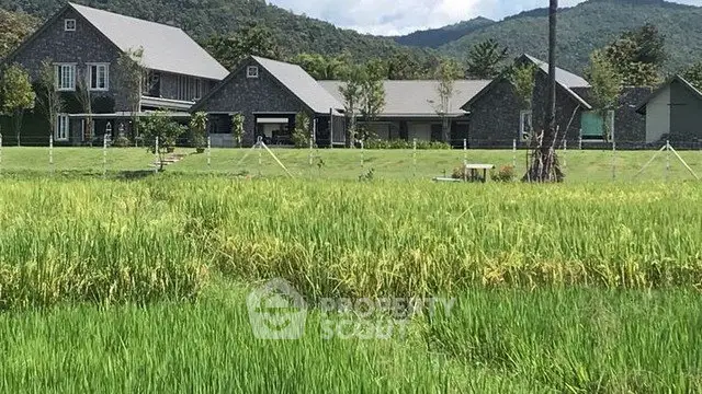 Charming countryside estate with lush green fields and mountain backdrop