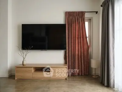 Modern living room with wall-mounted TV and stylish curtains