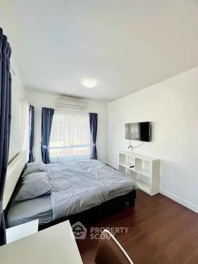 Modern bedroom with sleek design, featuring a mounted TV and elegant curtains, perfect for comfort and style.