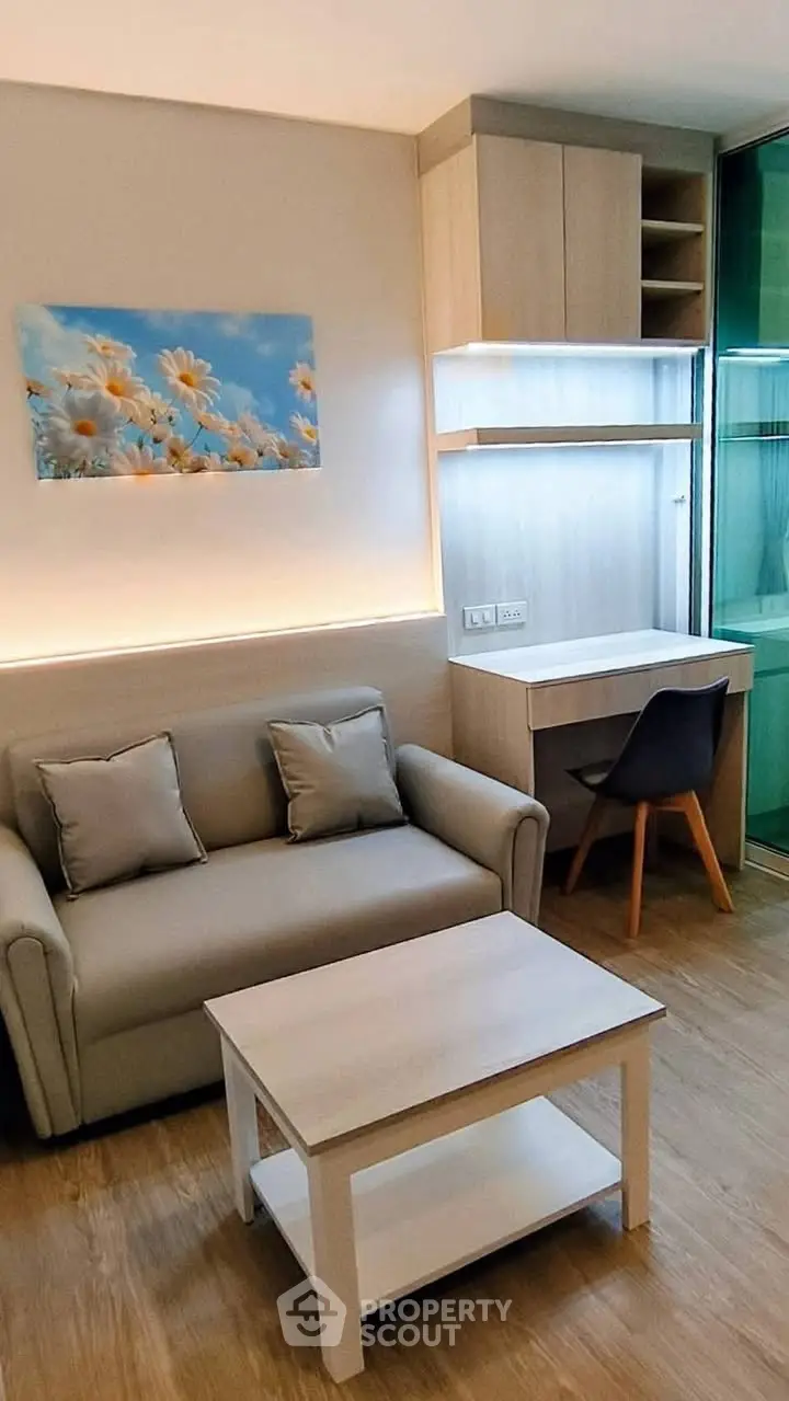 Modern living room with cozy sofa and stylish desk in a compact apartment.