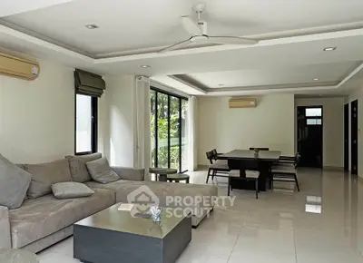 Spacious modern living room with elegant decor and large windows offering garden views.