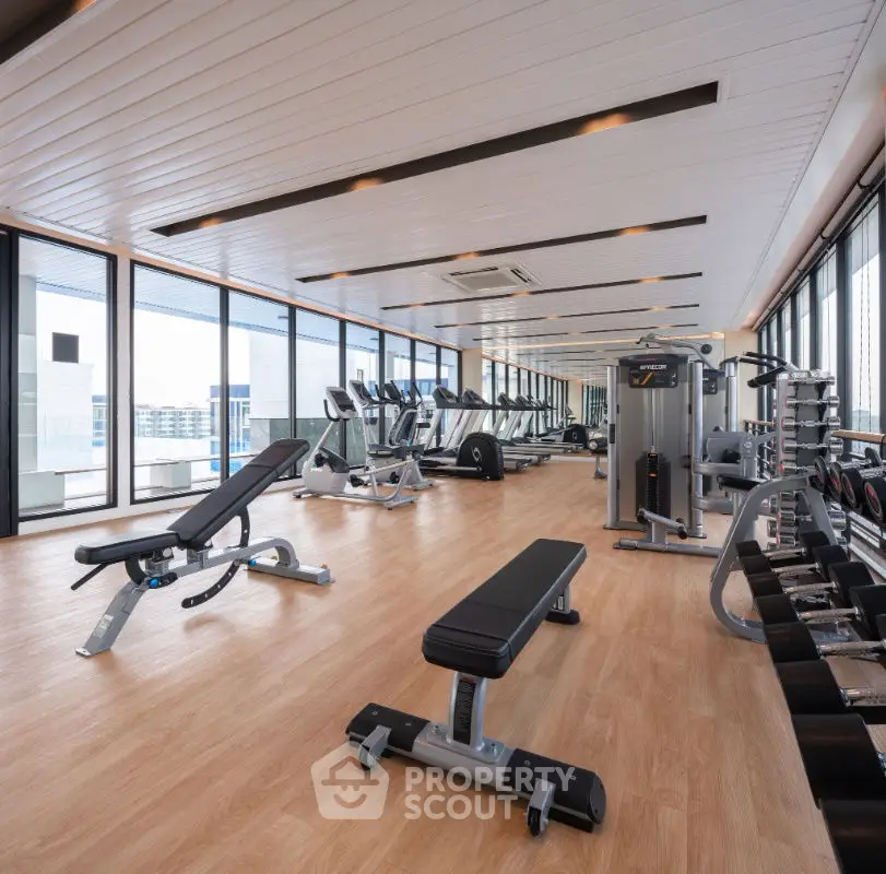 Spacious modern gym with state-of-the-art equipment and panoramic city views.