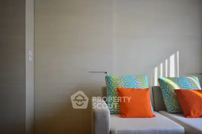 Modern living room with stylish sofa and colorful cushions, perfect for relaxation and comfort.