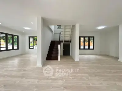 Spacious modern living room with wooden flooring and staircase
