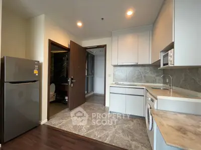 Modern kitchen with sleek cabinets, marble countertops, and integrated appliances in a stylish apartment.