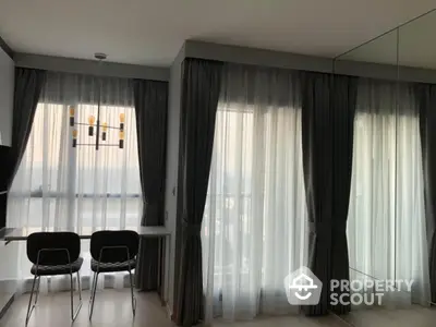 Modern apartment dining area with floor-to-ceiling windows and elegant curtains