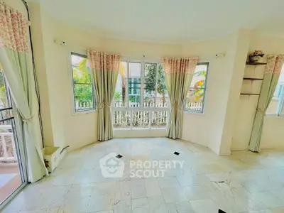 Bright and airy room with large windows and elegant curtains, perfect for a cozy living space.