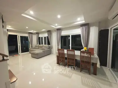 Spacious modern living room with large windows and elegant dining area