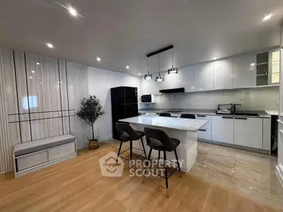 Modern kitchen with sleek design, featuring an island, contemporary lighting, and integrated appliances.