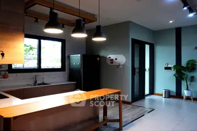 Modern kitchen with sleek design, featuring a black refrigerator and stylish lighting.