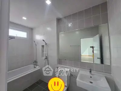 Modern bathroom with bathtub and sleek fixtures in a contemporary home.