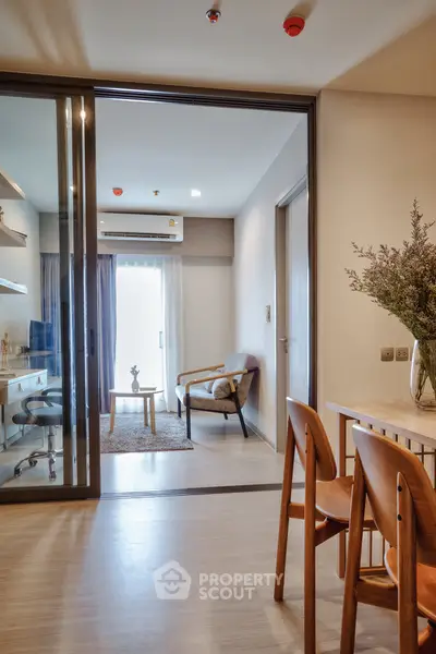 Modern apartment interior with stylish living room and study area, featuring elegant furniture and natural light.