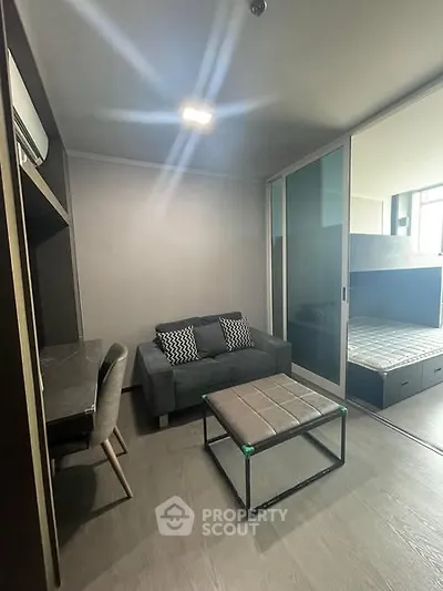 Modern compact living room with sofa and study area in stylish apartment