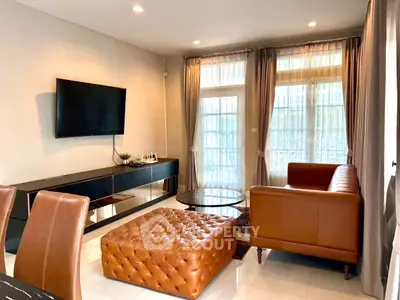 Stylish living room with leather furniture and wall-mounted TV, perfect for modern comfort and relaxation.
