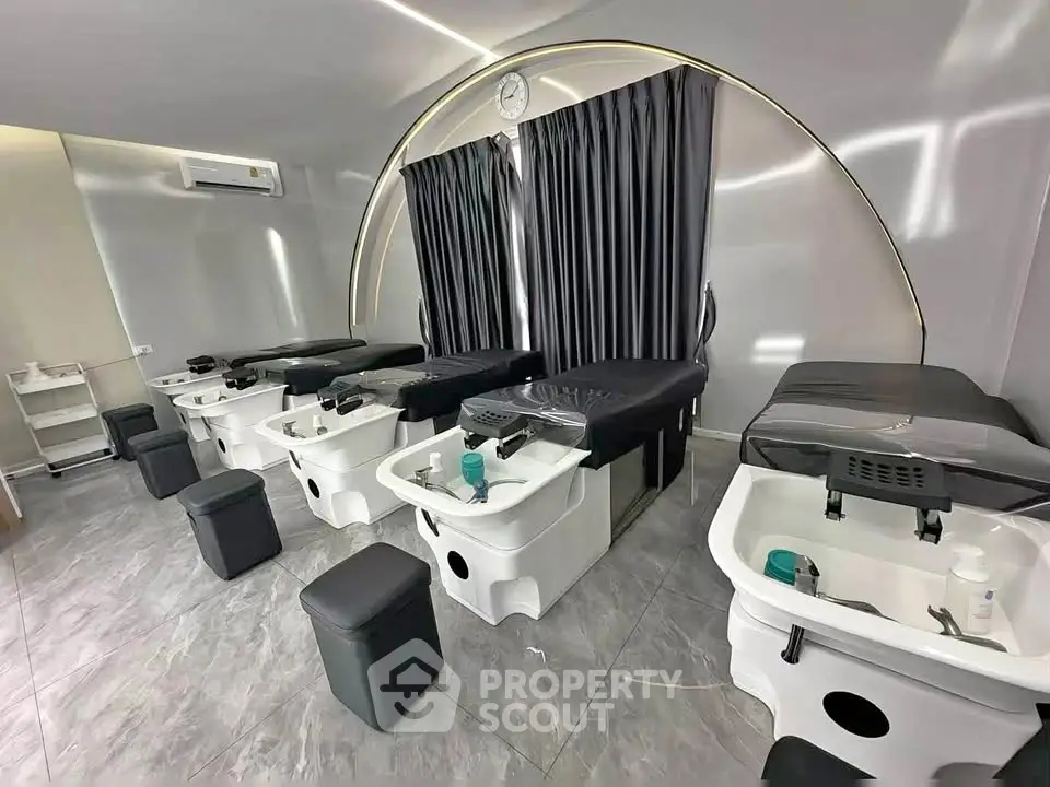Modern spa room with sleek massage tables and foot baths, perfect for relaxation and rejuvenation.