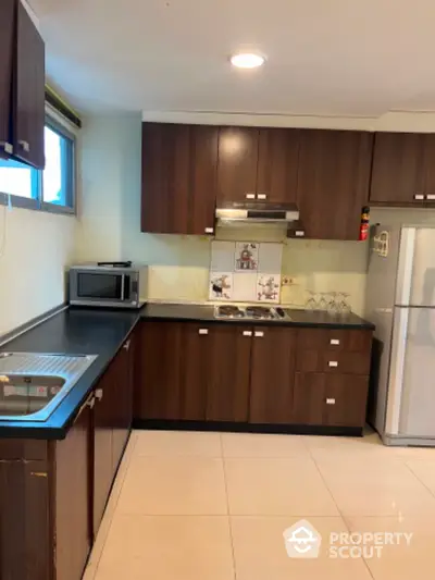 Modern kitchen with dark wood cabinets and stainless steel appliances