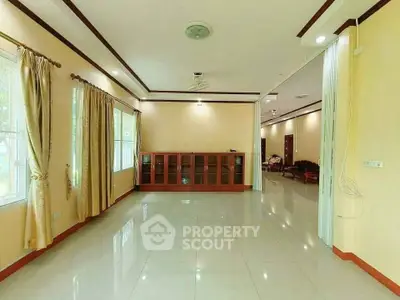 Spacious living room with large windows and elegant curtains in a modern home.