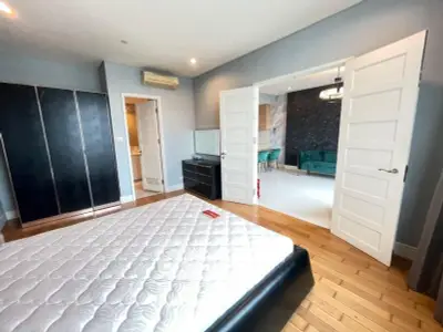 Spacious bedroom with elegant double doors leading to a stylish living area, featuring modern furniture and decor.
