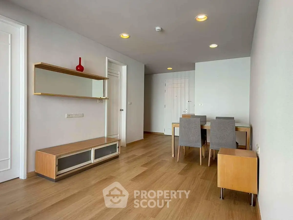 Modern dining area with wooden flooring and stylish furniture in a contemporary apartment.