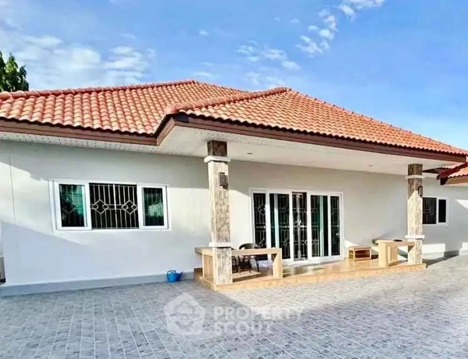 Charming single-story home with red-tiled roof and spacious patio, perfect for family living.