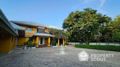 Stunning yellow villa with spacious courtyard and lush greenery