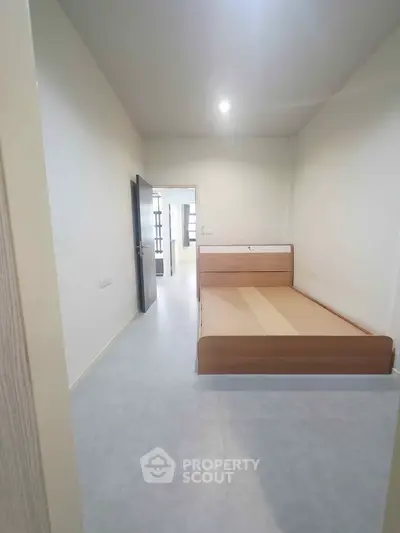 Spacious bedroom with modern bed frame and minimalist design, perfect for a cozy living experience.