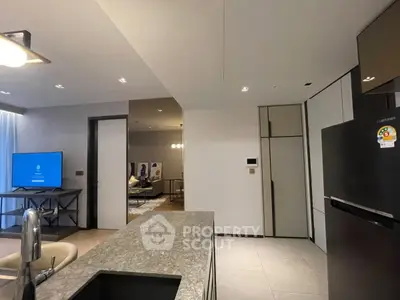 Modern open kitchen with sleek design and spacious living area in luxury apartment.