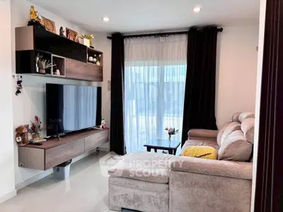Modern living room with plush sectional sofa and wall-mounted TV, featuring elegant decor and natural light.