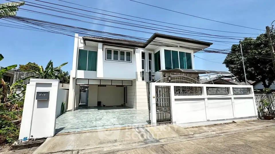 Modern two-story house with spacious driveway and sleek design in a suburban neighborhood.
