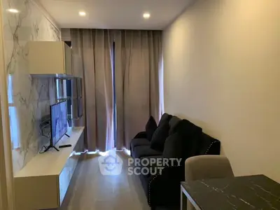 Modern living room with sleek marble wall, cozy black sofa, and mounted TV for stylish urban living.