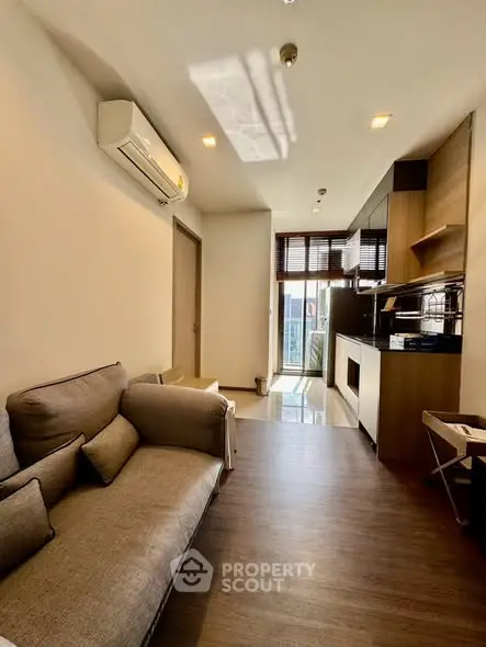 Modern living room with open kitchen and stylish decor in a cozy apartment.