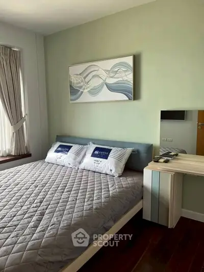 Cozy bedroom with modern decor and natural light in a stylish apartment.