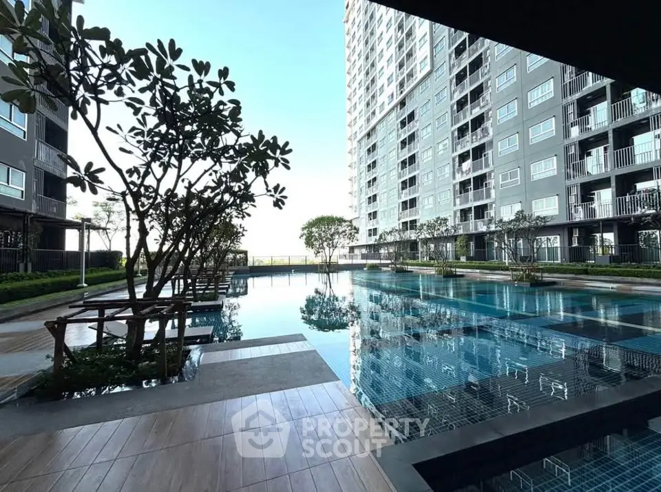 Luxurious high-rise building with stunning pool and landscaped surroundings, perfect for modern living.
