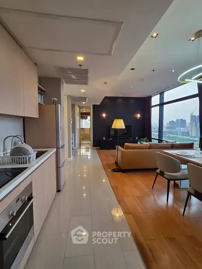 Spacious open-layout kitchen and living room with city view, modern appliances, and elegant decor.
