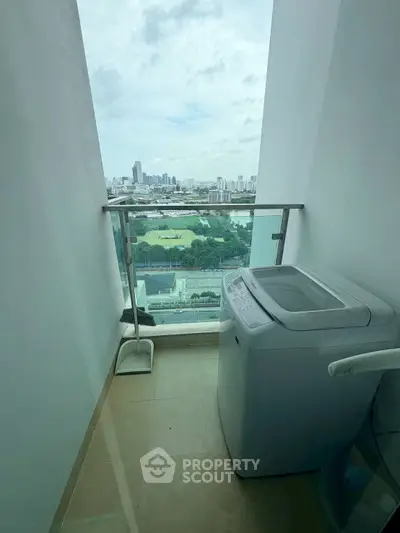 Compact balcony with washing machine and stunning city view, perfect for urban living convenience.