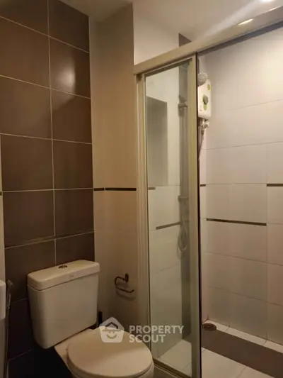 Modern bathroom with sleek shower and tiled walls in a contemporary apartment.