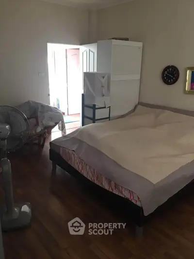 Cozy bedroom with wooden flooring and minimalistic decor