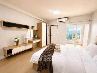 Spacious bedroom with modern decor and balcony view in a stylish apartment.
