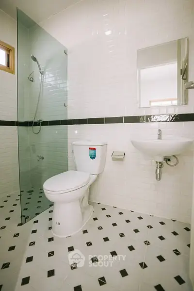 Modern bathroom with glass shower and sleek white tiles