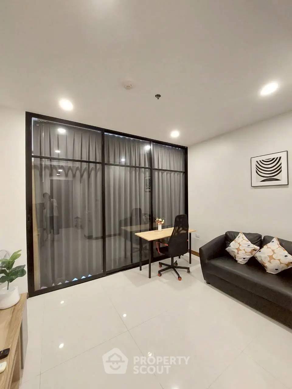 Modern living room with sleek furniture and large window, perfect for urban living.