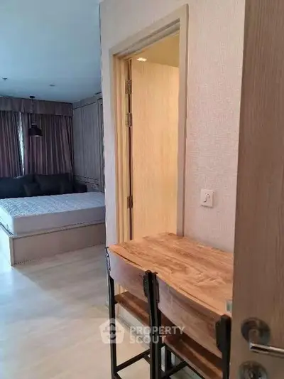 Cozy apartment interior with bedroom and study area, featuring modern furnishings and natural light.