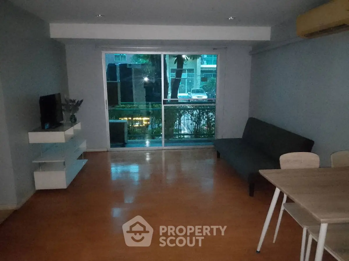 Spacious living room with modern decor and large window view.